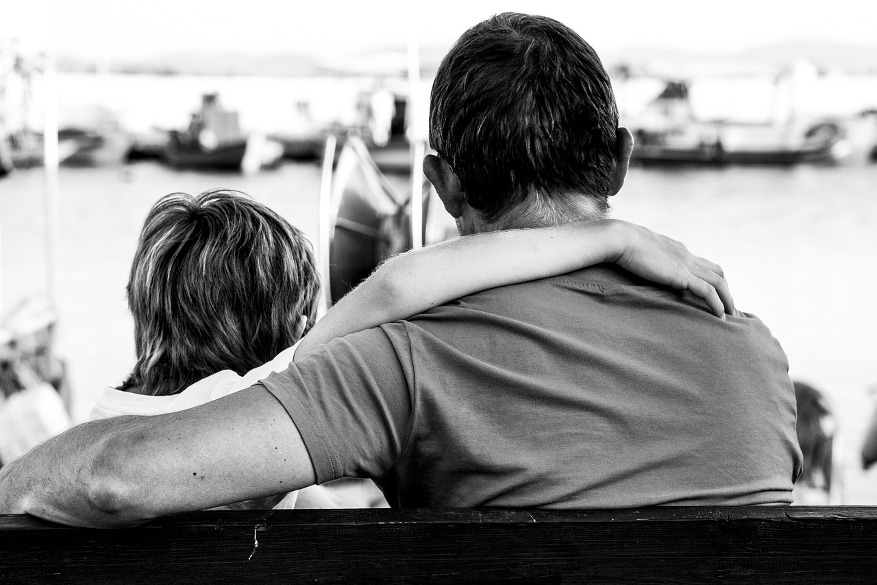 a father with his son looking at boats on the water