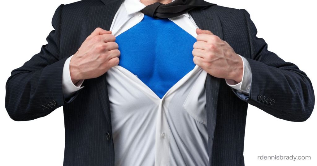 a man ripping off his suit who has a superhero outfit underneath