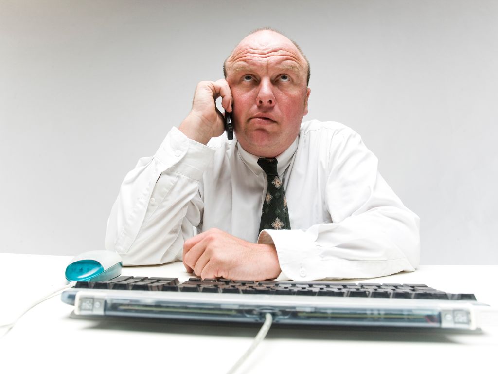 a man on the phone on hold waiting on customer support