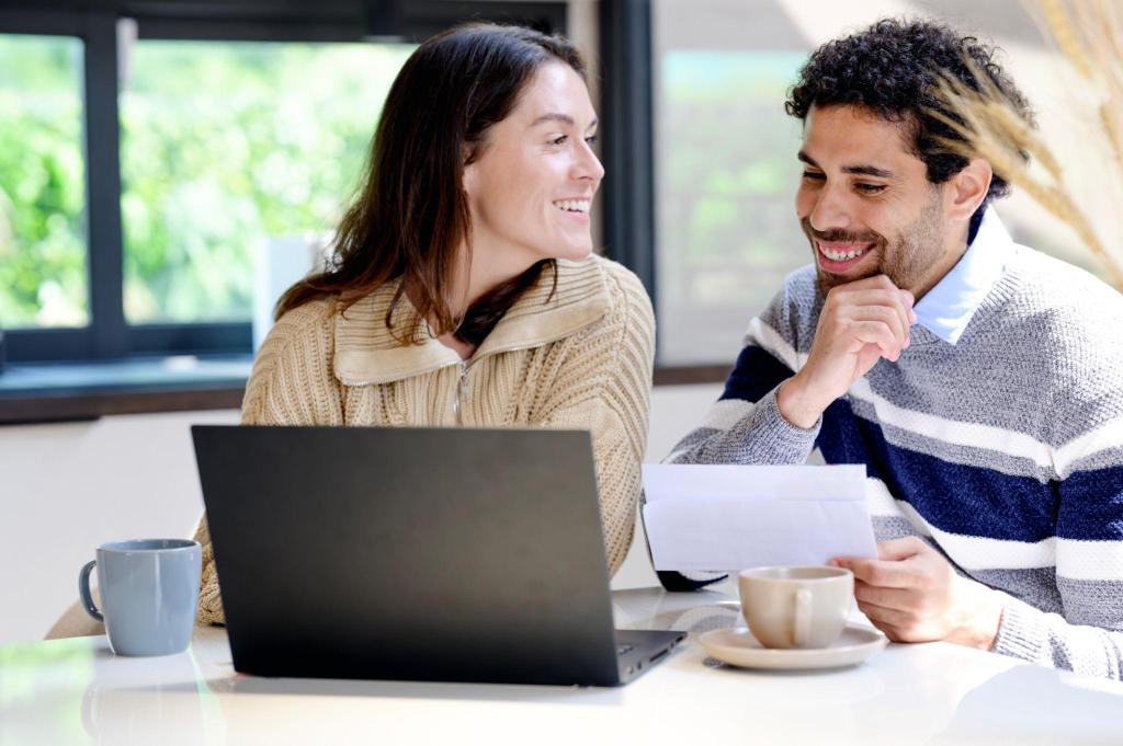 a young couple looking at computer researching rental properties for investment